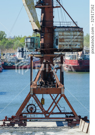 Crane in river port. Heavy cranes unloading metal Crane in river port. Heavy cranes unloading metal 32917162