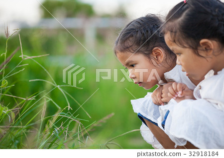 Two asian girl having fun and playing with nature Two asian girl having fun and playing with nature 32918184