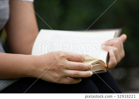 Woman hand holding and reading a book Woman hand holding and reading a book 32918221