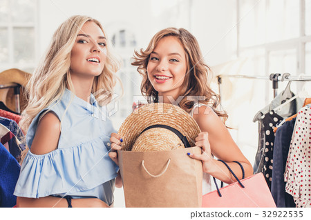 The two young pretty girls looking at dresses and The two young pretty girls looking at dresses and 32922535