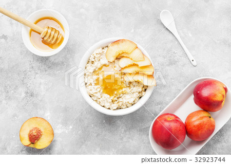 Oatmeal with nectarine, honey on a gray background Oatmeal with nectarine, honey on a gray background 32923744