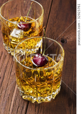 Cocktail from whisky with cherry in two glasses 32923761