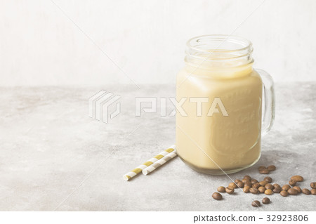 Milk pouring in ice coffee in a tall glass 32923806