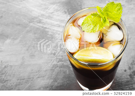 Cocktail Cuba Libre in glass on a dark background Cocktail Cuba Libre in glass on a dark background 32924159