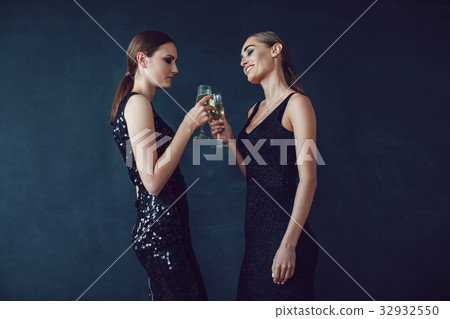 Attractive women in cocktail dresses are holding 32932550