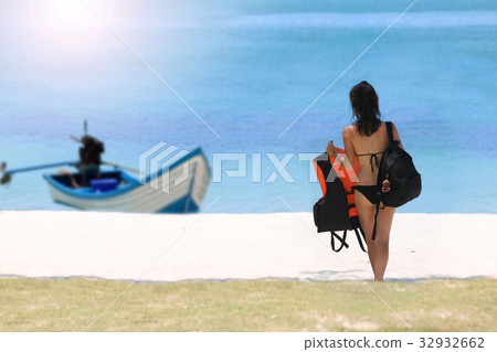 Tourist girl with luggage on the beach Tourist girl with luggage on the beach 32932662