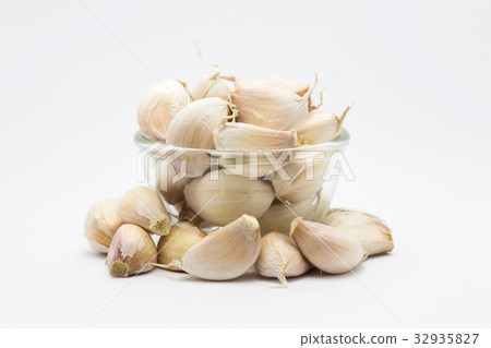 Garlic on glass cup, on white  32935827