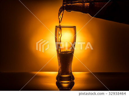 dark glass beer pouring on light background dark glass beer pouring on light background 32938464