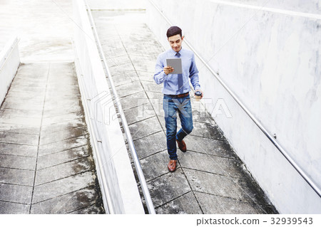 Young motivation Businessman use Tablet while walk Young motivation Businessman use Tablet while walk 32939543