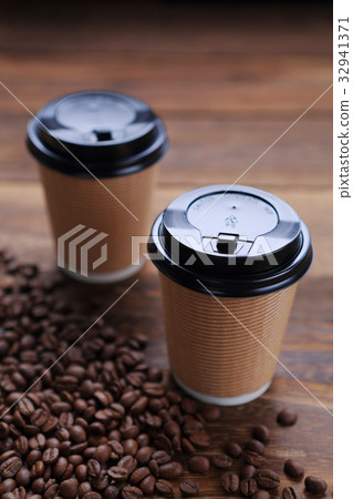 Hot coffee and coffee beans sprinkled in a paper cup 32941371