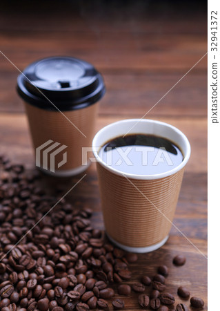 Hot coffee and coffee beans sprinkled in a paper cup 32941372
