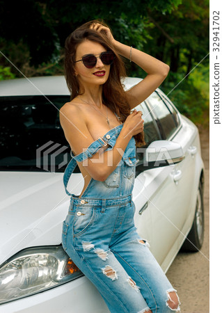 sexy glamour Lady stands in jeans jumpsuit near sexy glamour Lady stands in jeans jumpsuit near 32941702