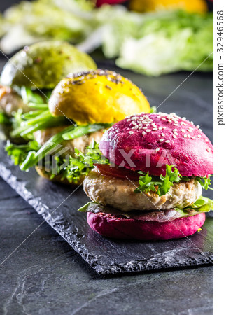 Colored green, yellow and purple burgers on slate 32946568