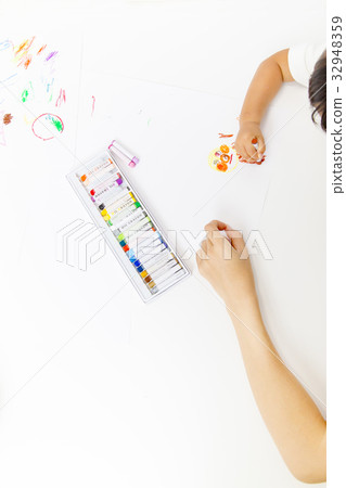 The hand of a little girl and an adult woman who paints 32948359