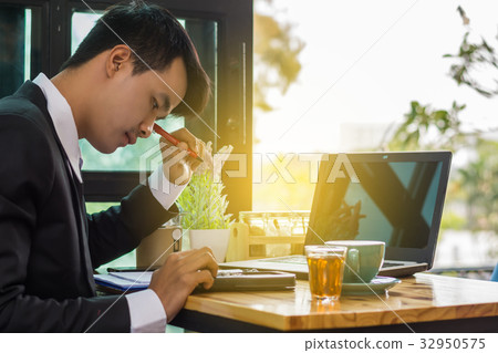 Business man sitting on a calculator to figure 32950575