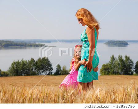 little girl hugging her mother in a wheat field little girl hugging her mother in a wheat field 32952780