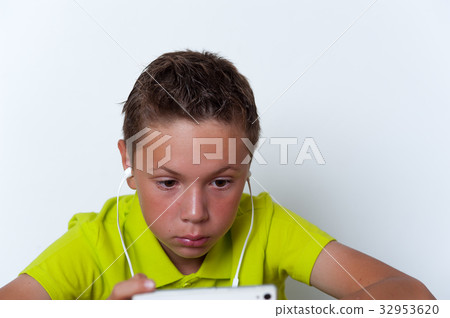 Pensive tween wearing earphones with smartphone 32953620