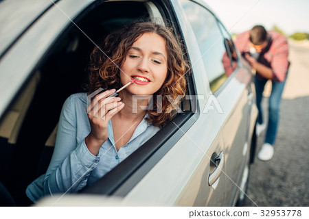 Man pushing a broken car, woman driver 32953778