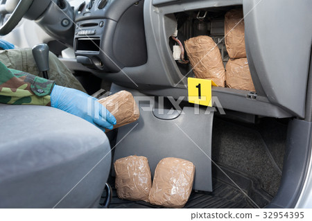 Police officer holding drug package 32954395