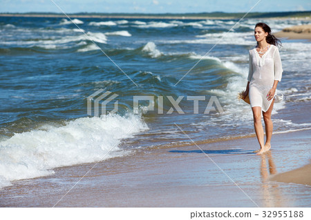 Young woman walking on white sand to beautiful beach, Baltic Sea, Poland Young woman walking on white sand to beautiful beach, Baltic Sea, Poland 32955188