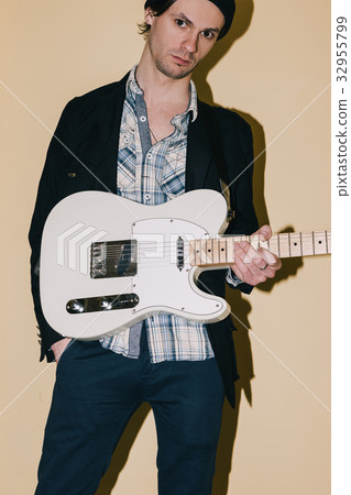 Male hipster posing with electric guitar closeup 32955799
