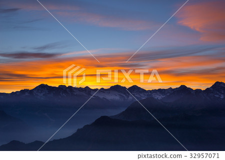 Colorful sunlight behind majestic mountain peaks Colorful sunlight behind majestic mountain peaks 32957071