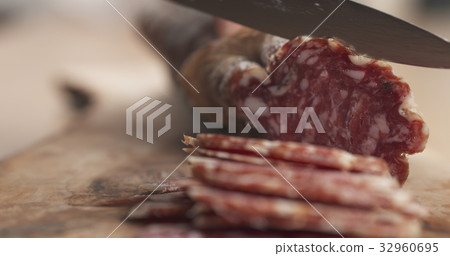 slicing dried italian salami on table slicing dried italian salami on table 32960695