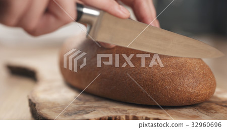 young female hands slicing rye wheat rustic bread young female hands slicing rye wheat rustic bread 32960696