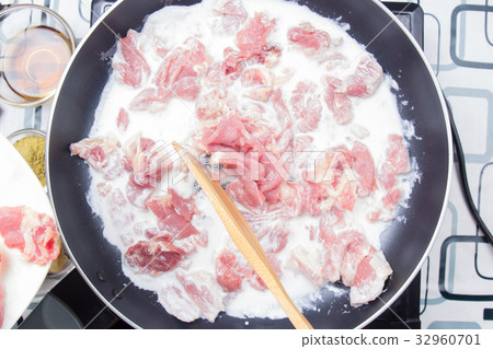 Chef stiring slice of beef with coconut milk 32960701