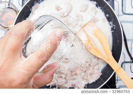 Chef pouring water fro cooking green curry Chef pouring water fro cooking green curry 32960703