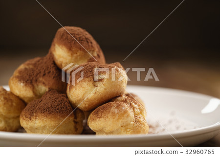 closeup shot of profiteroles covered with cocoa closeup shot of profiteroles covered with cocoa 32960765