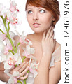 beautiful girl with big orchid on white 32961976