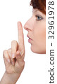 a girl holds a finger to lips gesture silently 32961978