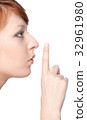 a girl holds a finger to lips gesture silently 32961980