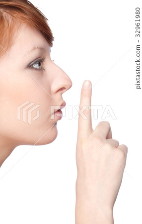a girl holds a finger to lips gesture silently 32961980
