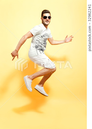 Handsome guy jumping looking at camera Handsome guy jumping looking at camera 32962241