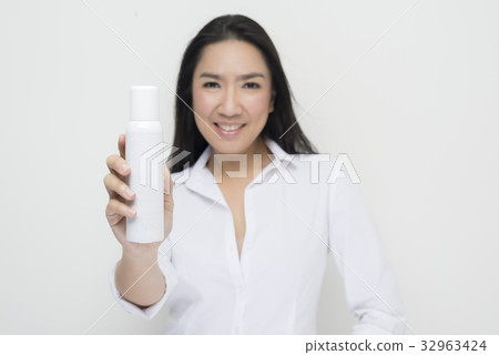 Beauty series: Woman holding white spray bottle 32963424