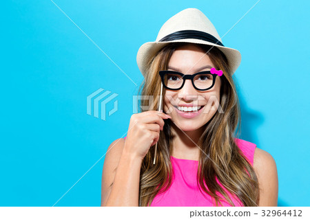 Young woman holding paper party sticks Young woman holding paper party sticks 32964412