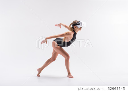 Somber youthful girl simulating bird dance 32965545