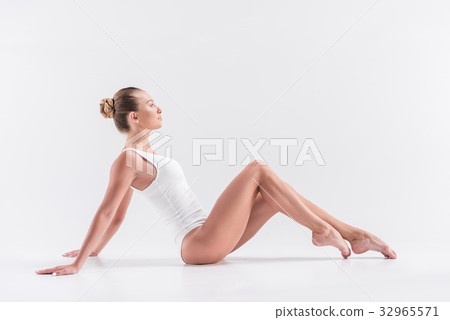 Somber young lady gymnast recreating while Somber young lady gymnast recreating while 32965571