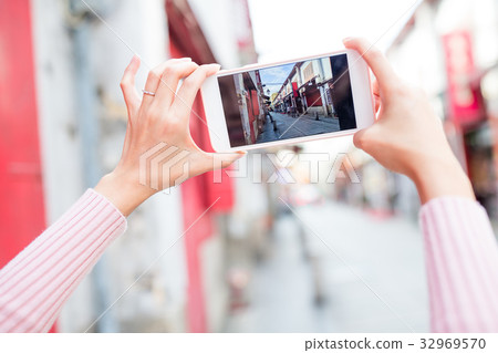 Woman taking photo on cellphone in Macau 32969570