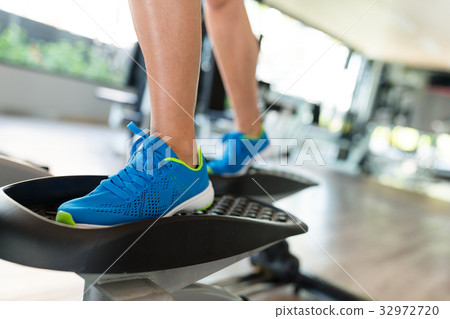 Sport woman working out on elliptical trainer in gym Sport woman working out on elliptical trainer in gym 32972720