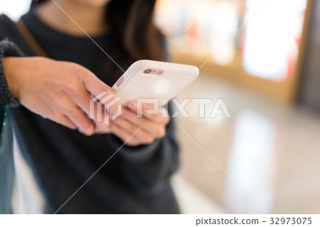 Woman using mobile phone to online Woman using mobile phone to online 32973075