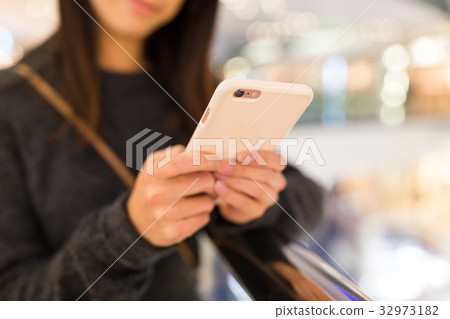 Woman use of mobile phone in shopping mall Woman use of mobile phone in shopping mall 32973182