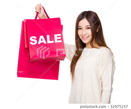 Young Woman hold with shopping bag showing a word sale 32975237