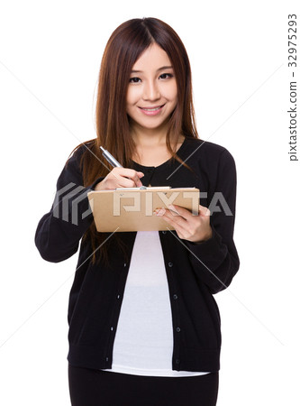 Young woman take note on clipboard Young woman take note on clipboard 32975293