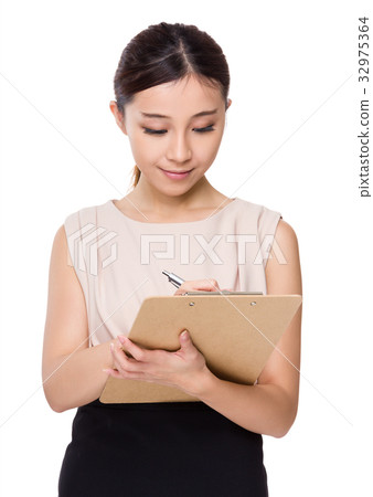 Asian Businesswoman write on clipboard Asian Businesswoman write on clipboard 32975364