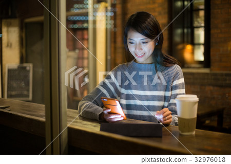 Woman use of tablet pc at night in cafe 32976018