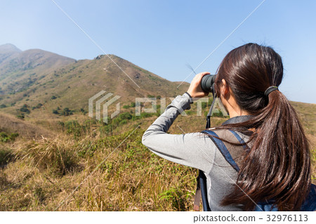 The back view of woman use of the binocular 32976113
