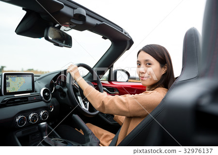 Woman driving a cabriolet car 32976137